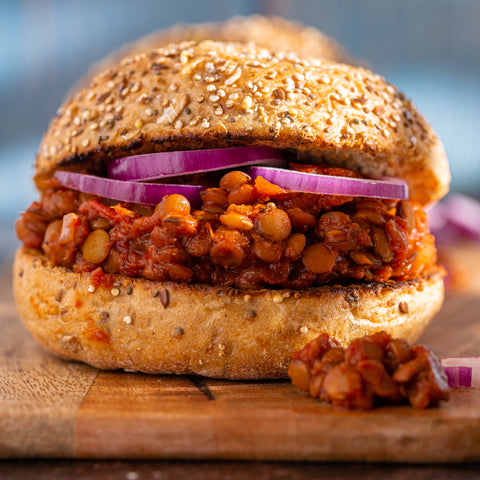 Lentil sandwich with red onion on a wooden board